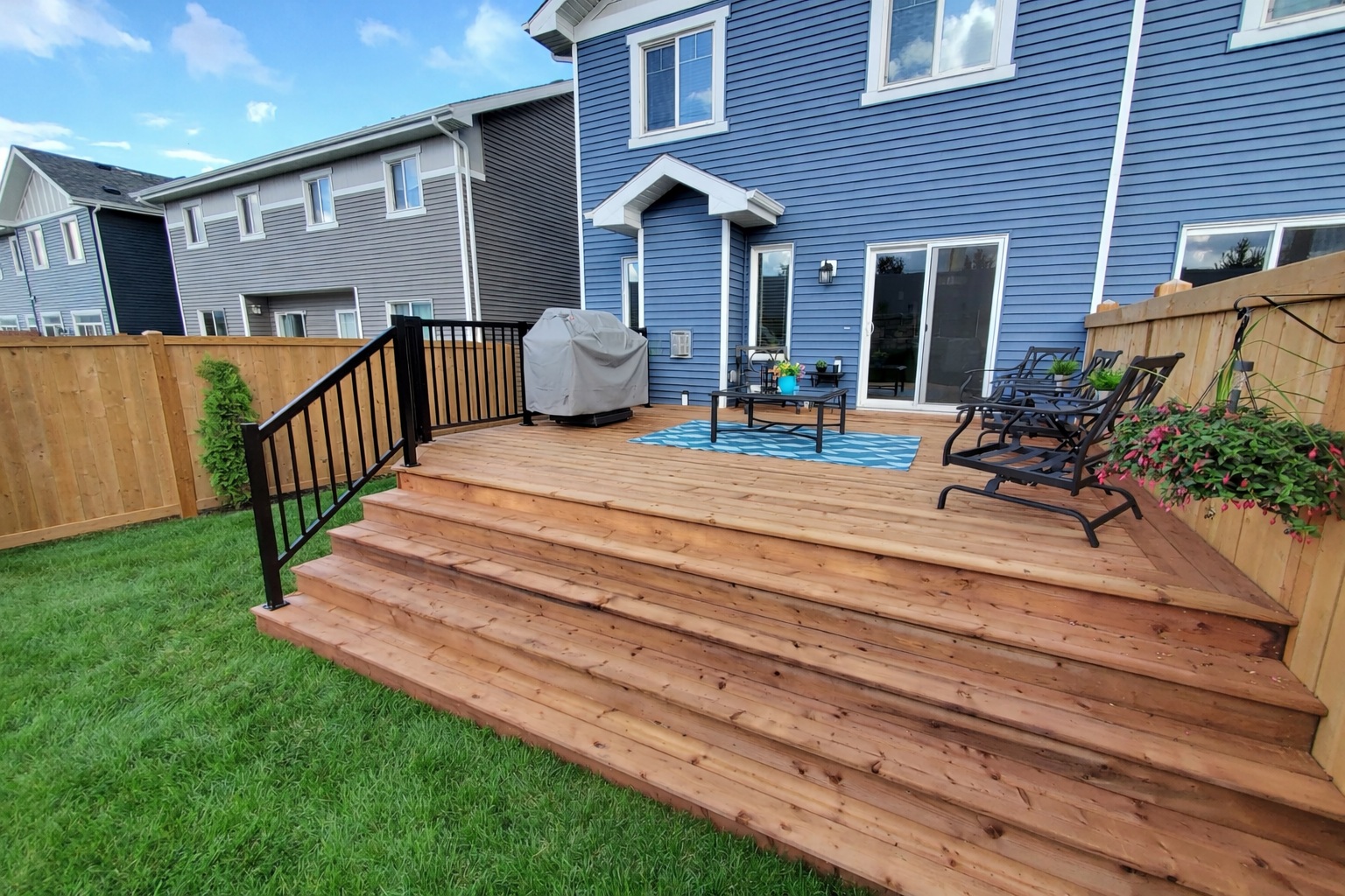 Grey composite deck with wide stairs and white aluminum railing built by Crestfield Decking in Edmonton, Alberta
