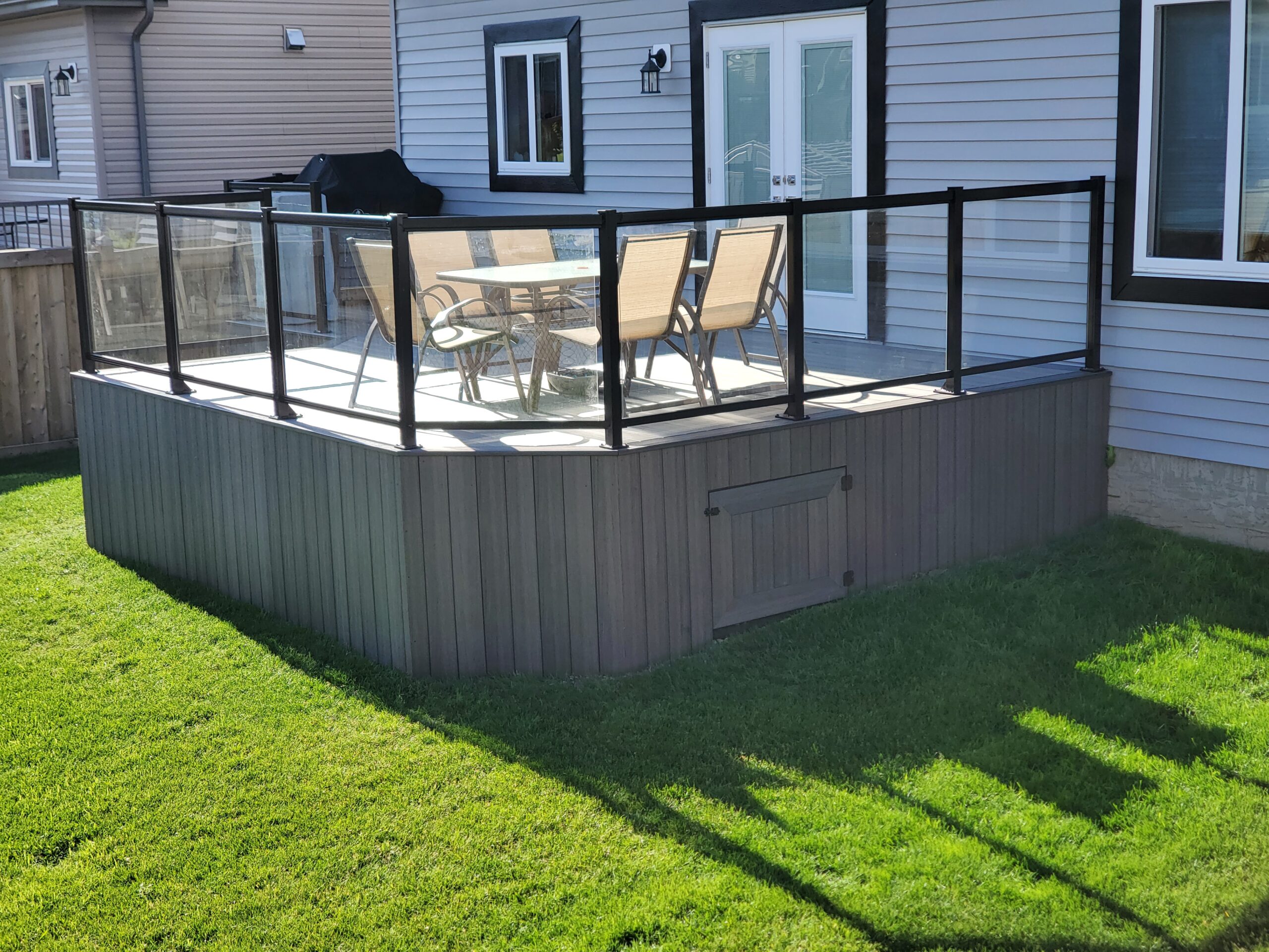 Side view of a composite deck with black aluminum and glass railing in Edmonton, Alberta