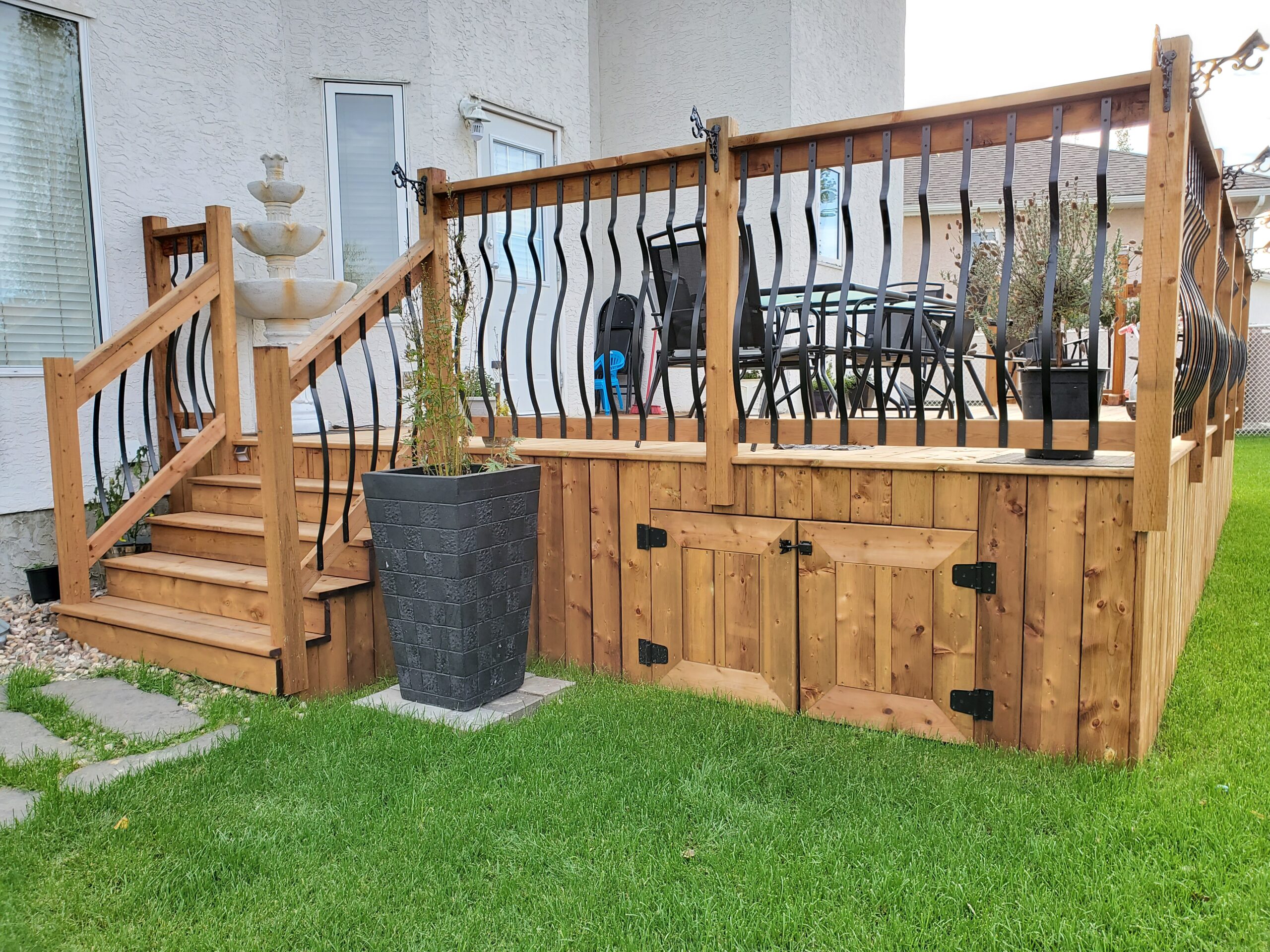 Custom deck with decorative wave balusters, built-in storage, and stairs built by Crestfield Decking in Edmonton, Alberta