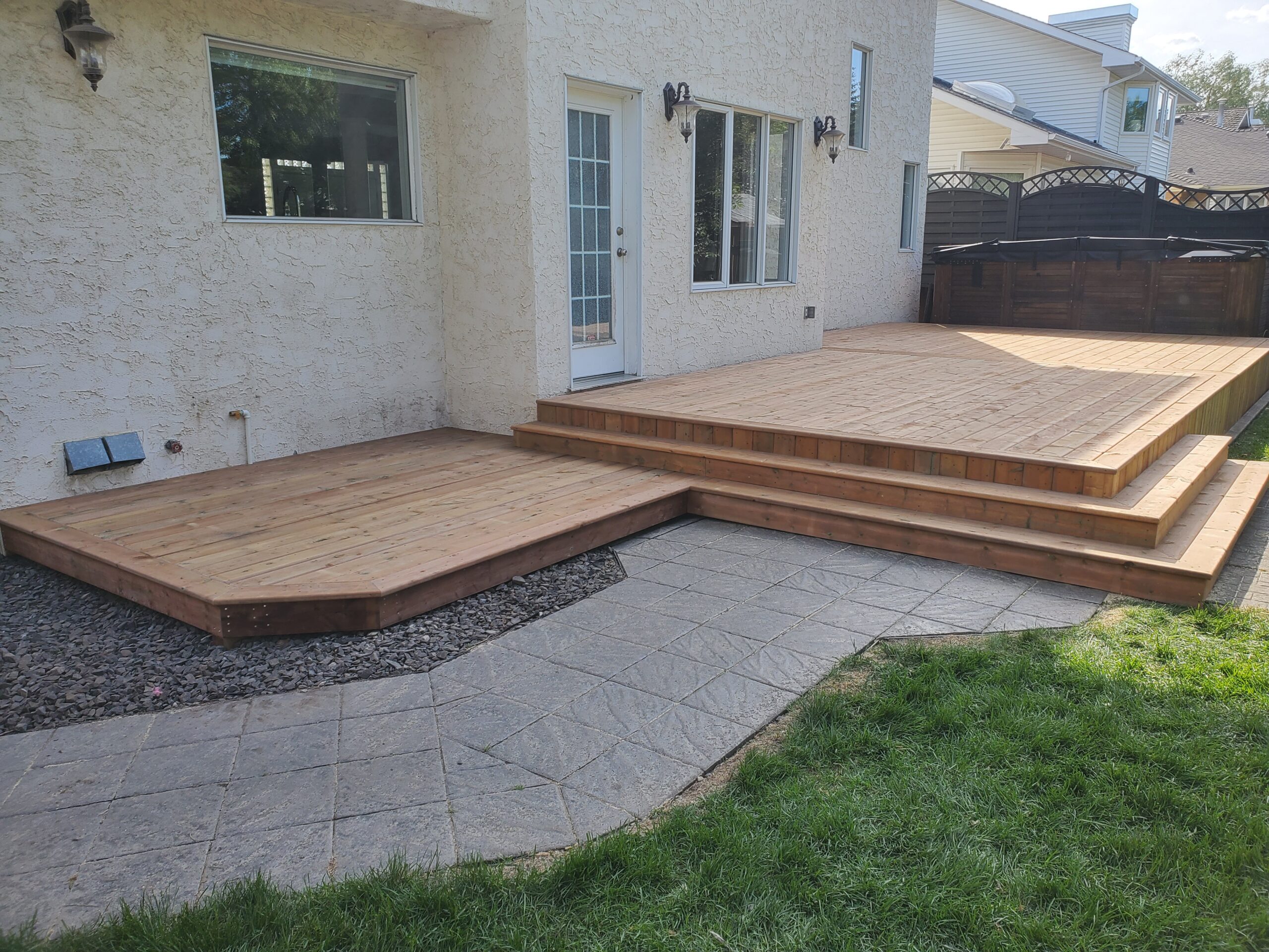 Multi-level pressure-treated deck with black aluminum railings and stairs in Edmonton
