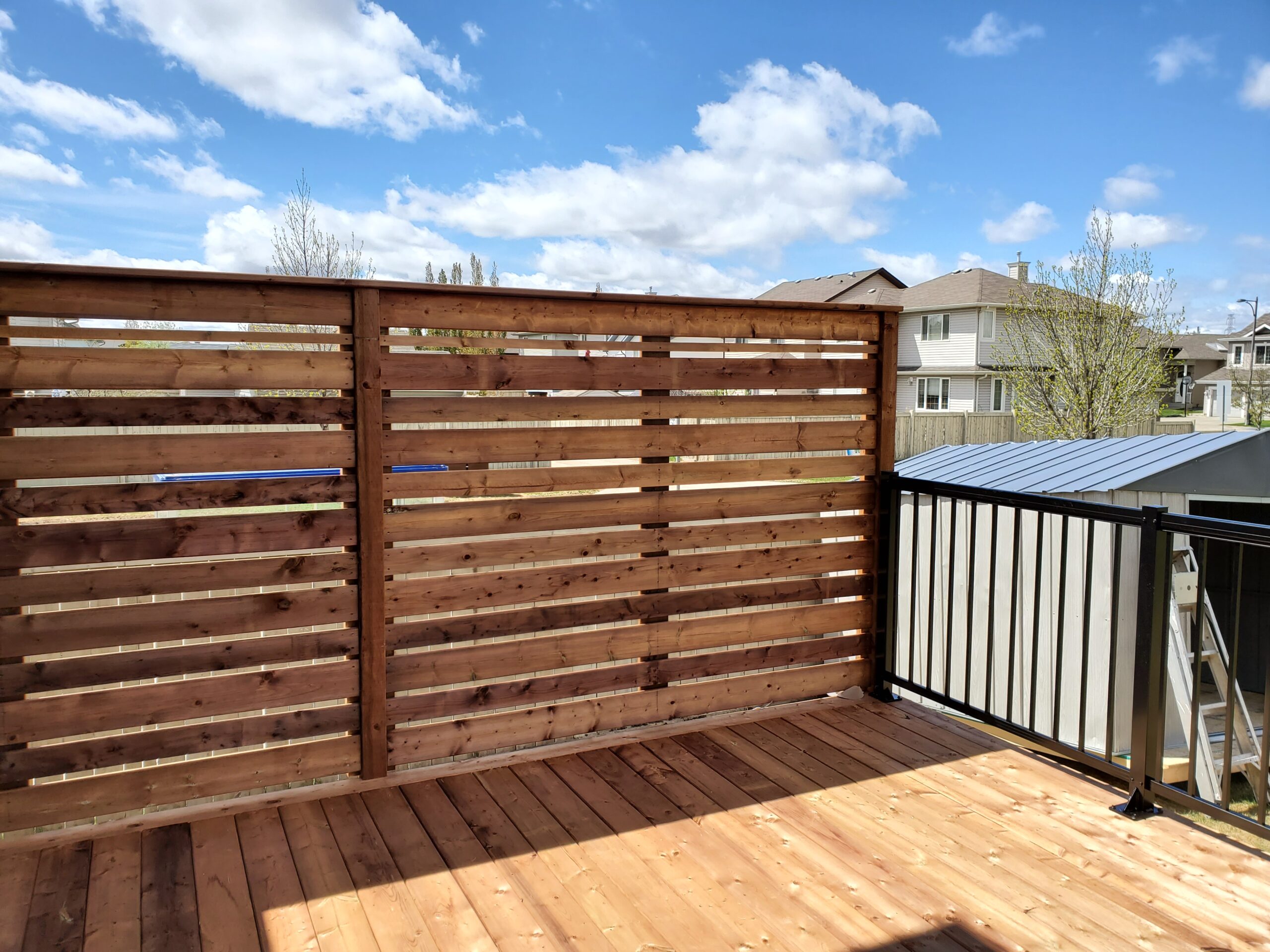 Cedar privacy screen on a residential deck with black aluminum railing in Edmonton, Alberta