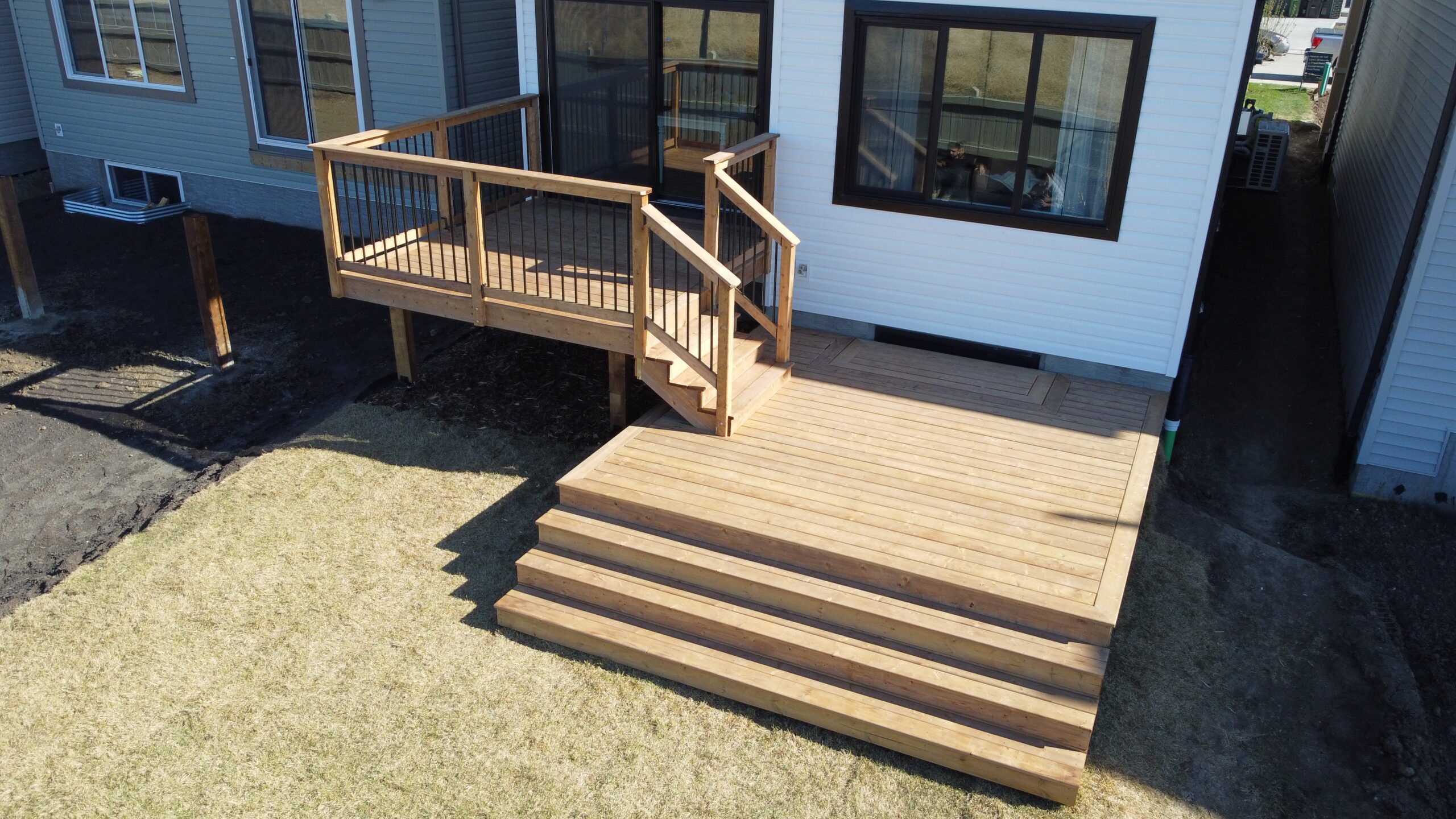 Multi-level deck with custom staircase and wood railing built by Crestfield Decking in Edmonton, Alberta