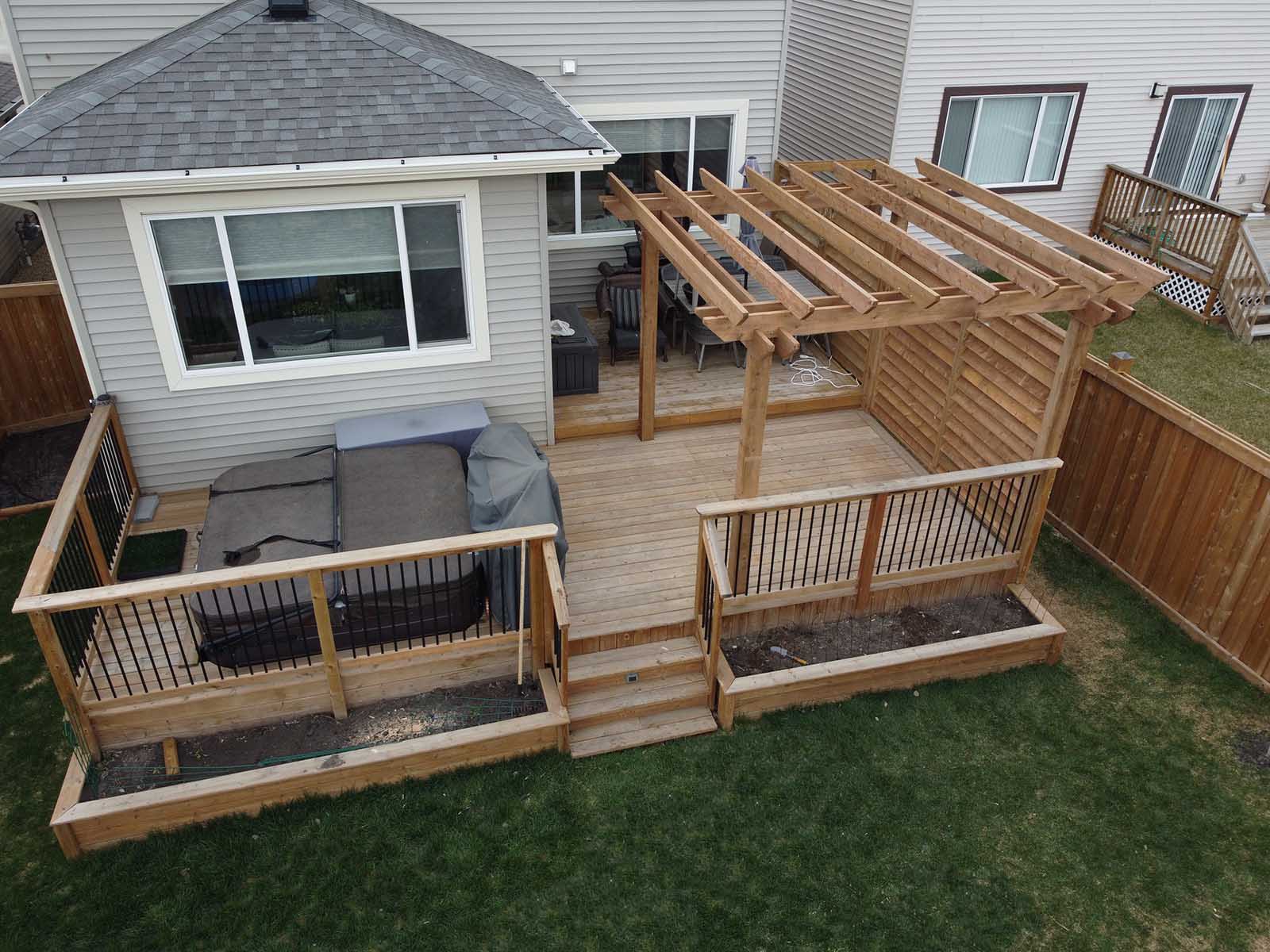 Wide view of custom pergola and privacy screen on backyard deck built by Crestfield Decking in Edmonton, Alberta