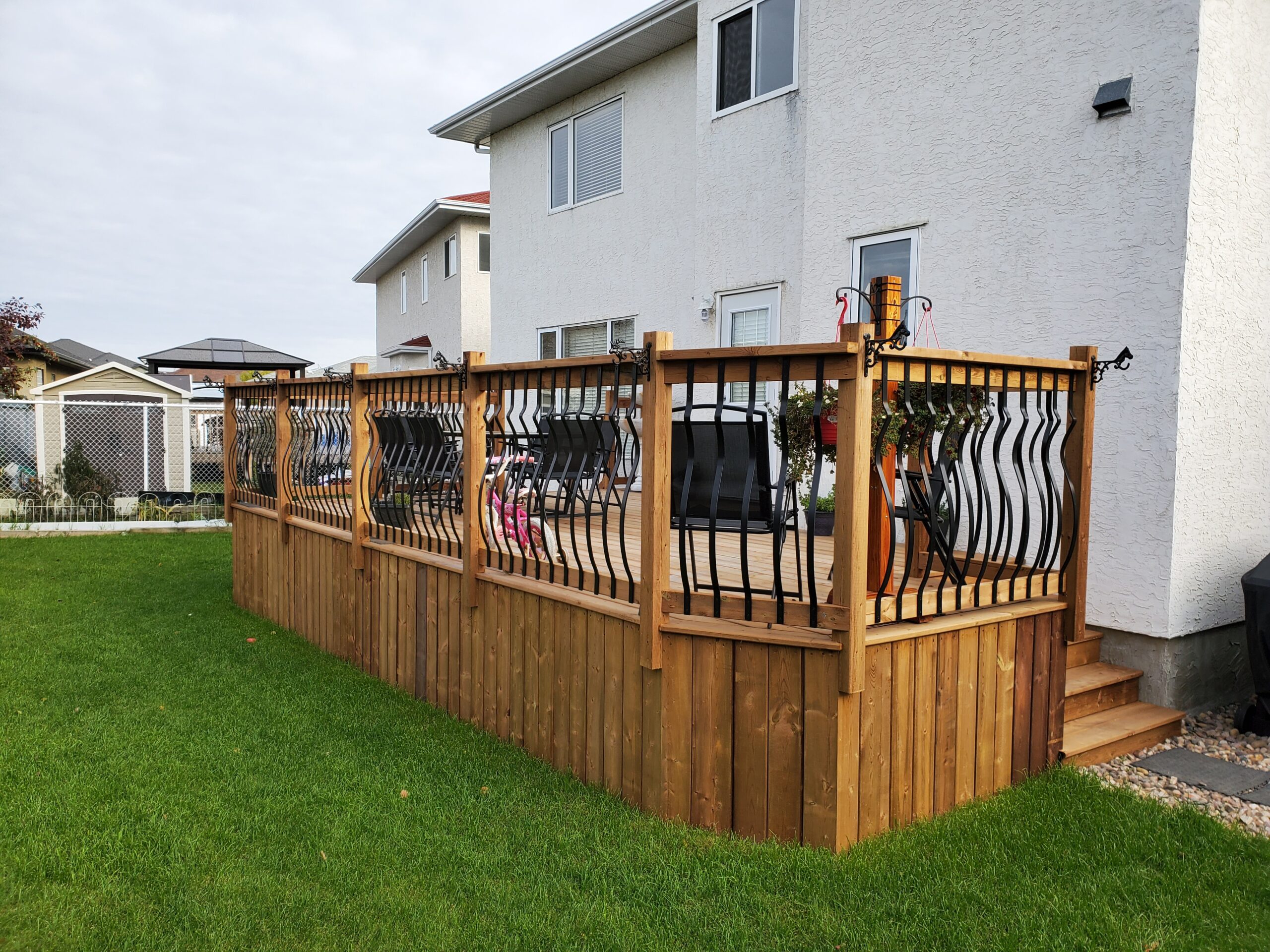 Pressure treated deck with decorative black metal railing built by Crestfield Decking in Edmonton, Alberta