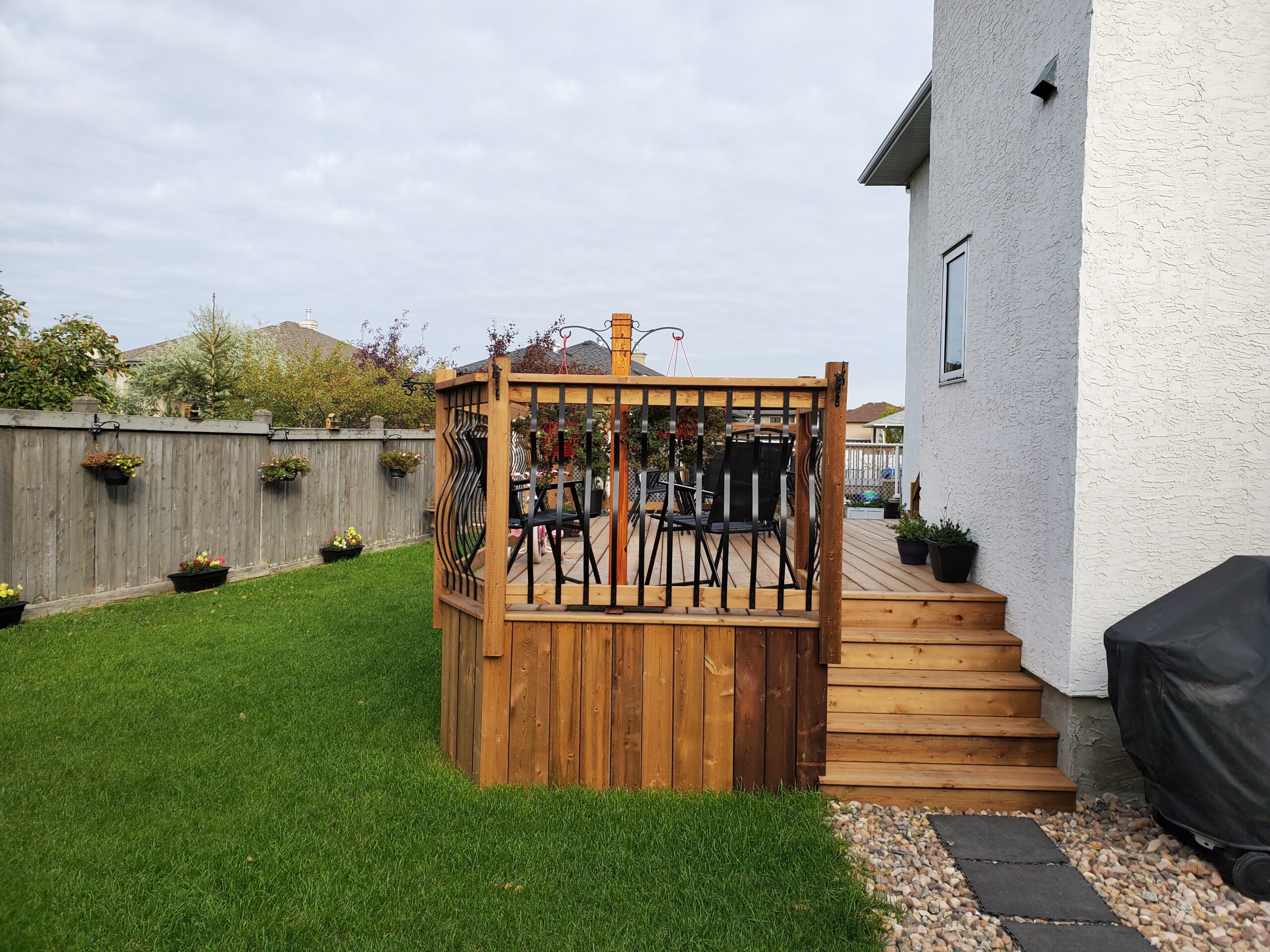 Side view of a pressure treated deck with decorative metal railing built by Crestfield Decking in Edmonton, Alberta