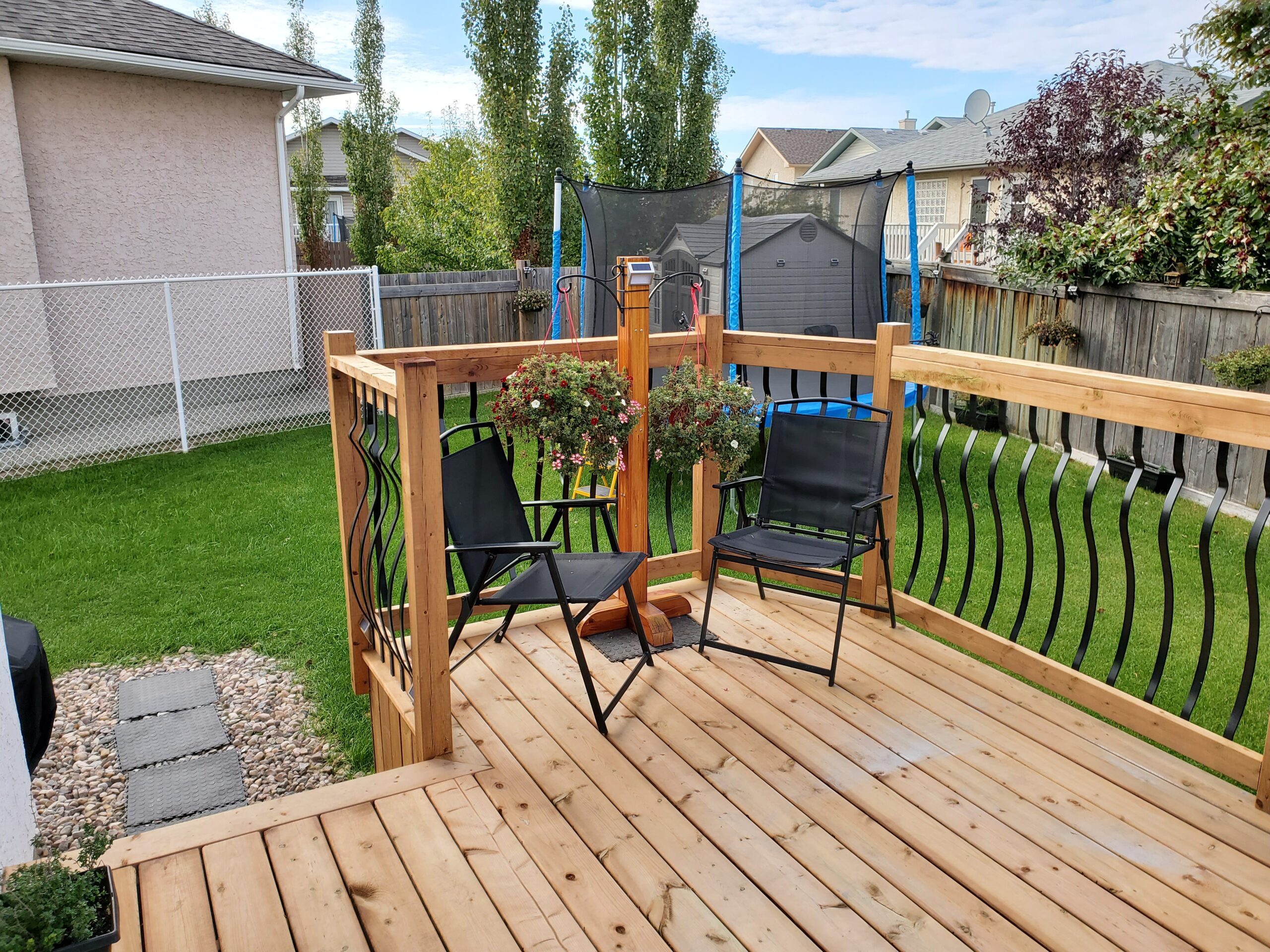 Pressure treated deck with picture frame finish and decorative metal railing built by Crestfield Decking in Edmonton, Alberta