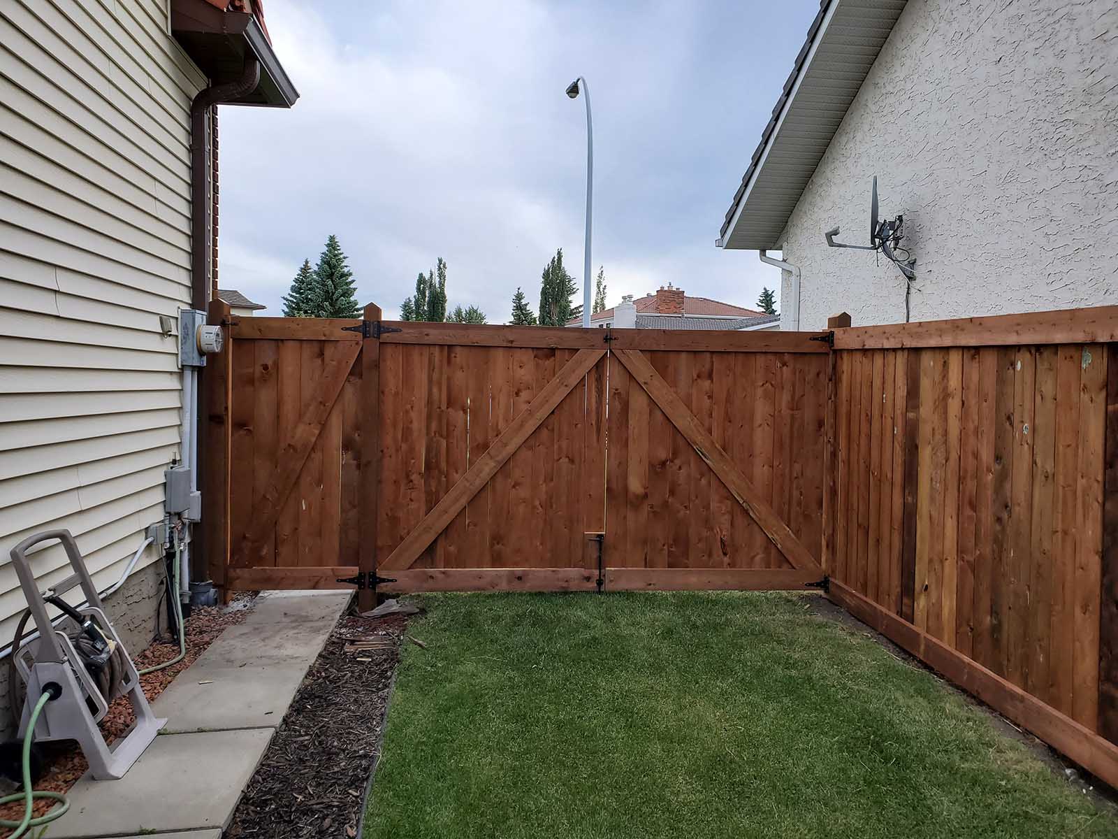 Pressure-treated double gate with heavy-duty hardware as part of privacy fence built by Crestfield Decking in Edmonton, Alberta