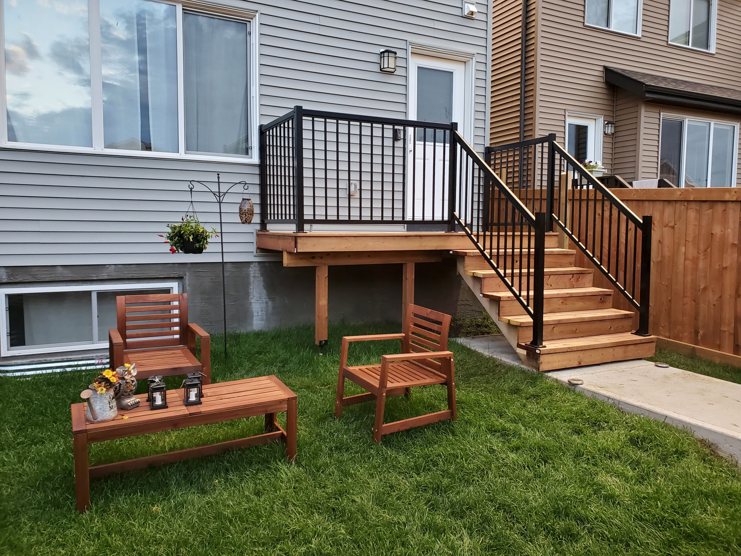 Pressure-treated backyard deck with black aluminum railing and custom stairs built in Edmonton, Alberta