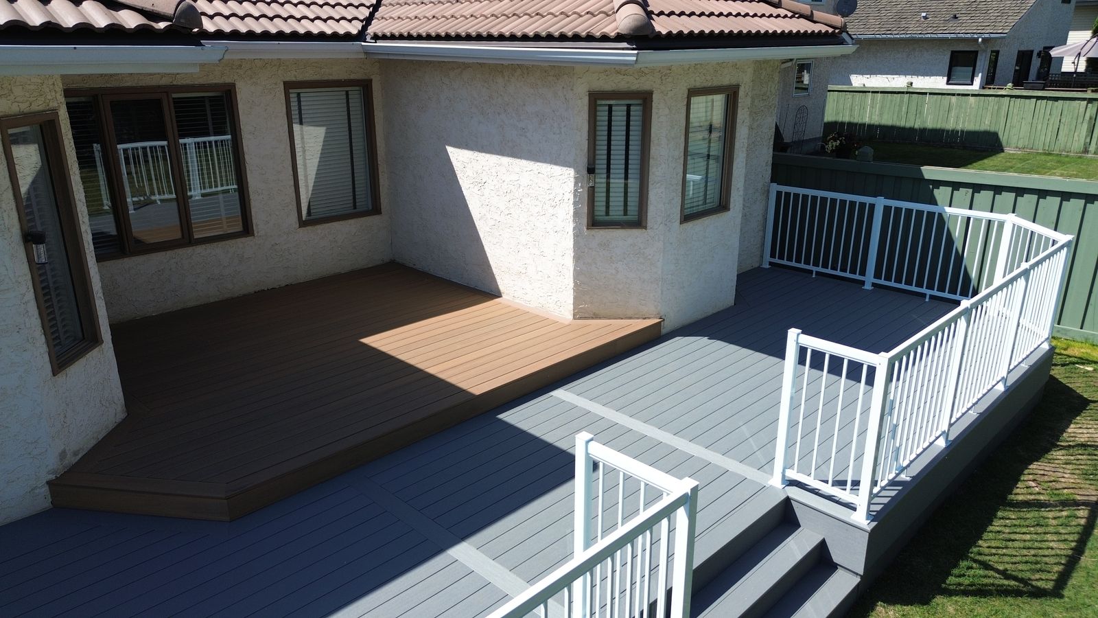 Composite deck with warm Coconut Husk decking against Maritime Grey composite boards in Wedgewood Heights, Edmonton, Alberta