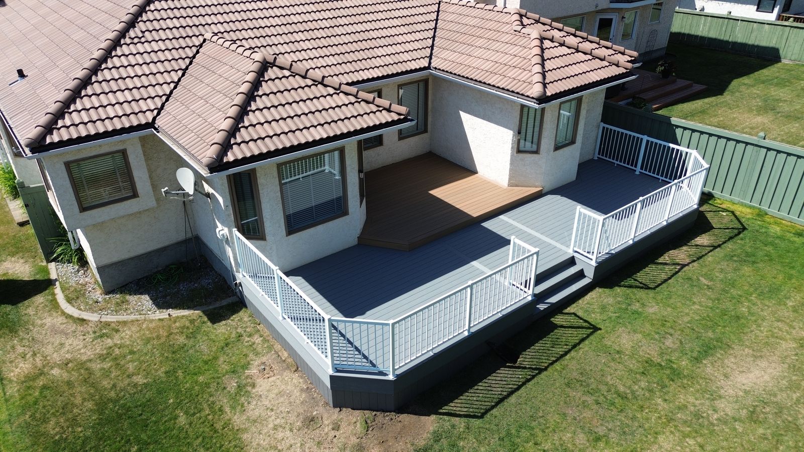 Aerial view of a multi-level two-tone composite deck wrapping around a home in Wedgewood Heights, Edmonton, Alberta