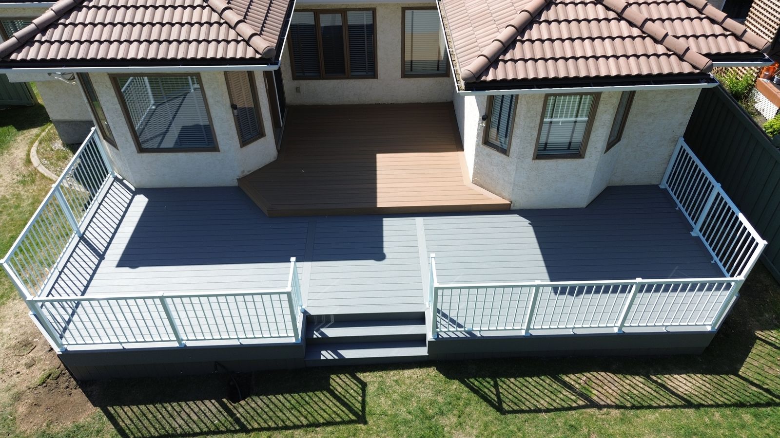 Aerial view of a multi-level two-tone composite deck wrapping around a home with stairs in Wedgewood Heights, Edmonton, Alberta