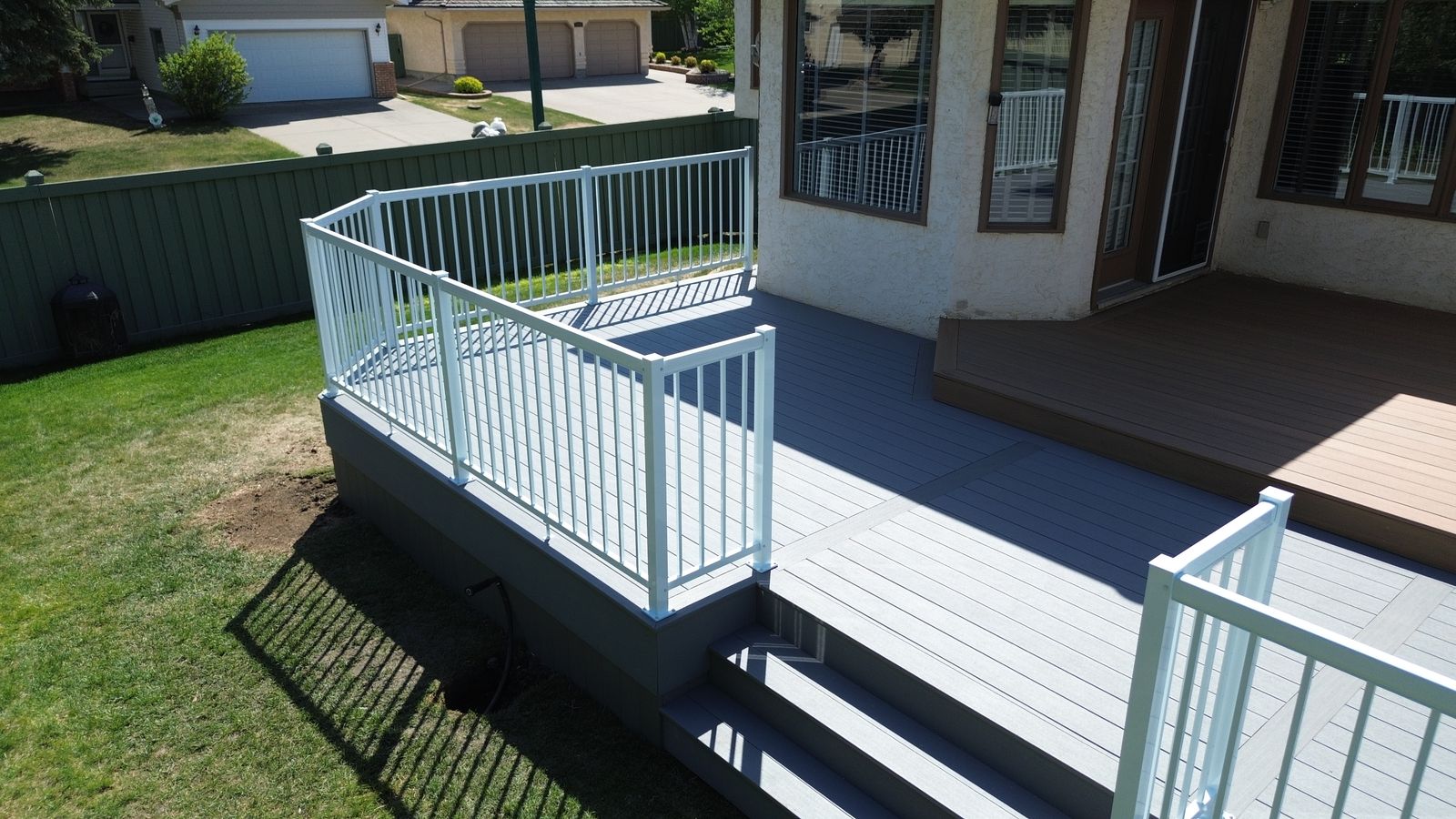 Two-tone composite deck with white aluminum railing and wide stairs in Wedgewood Heights, Edmonton, Alberta